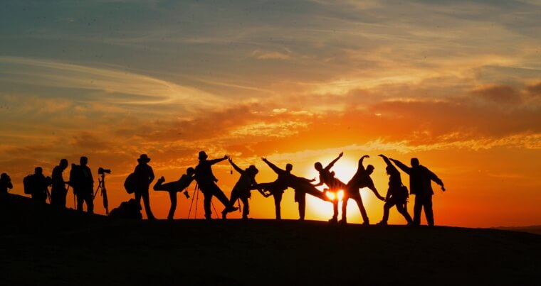 Silhouettes of people posing in front of the sunset