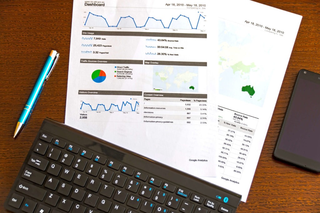 Marketing reports with a focus on Australia placed on a table next to a laptop